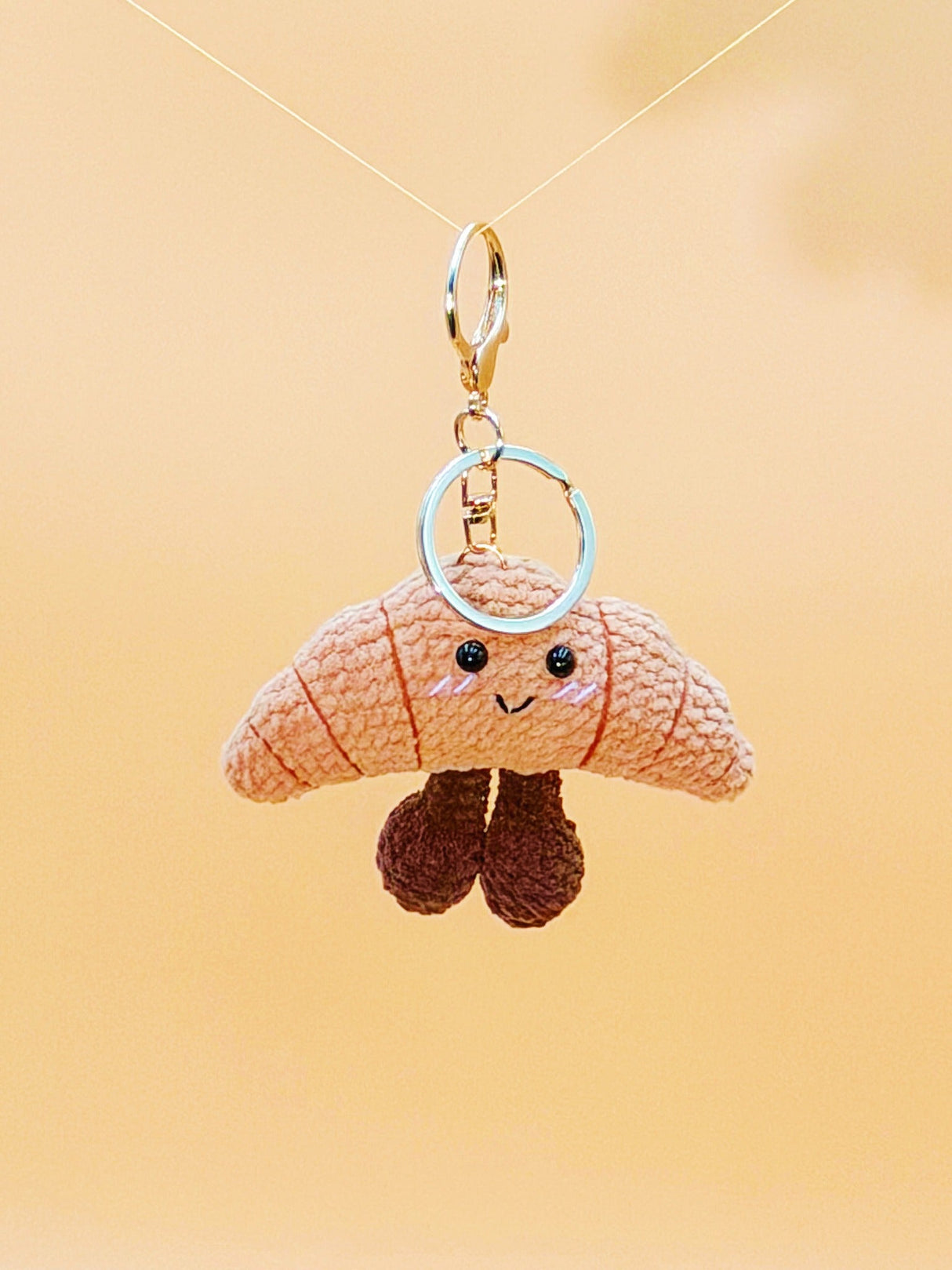 Smiling croissant handmade crochet keychain